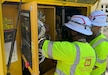 Two soldiers inspect an electrical panel.