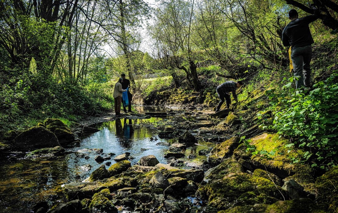 Volunteers search the Spangerbach creekbed for debris during the annual creek cleanup in Spangdahlem, Germany, April 25, 2026. The cleanup, organized annually since 1999, brings together German residents and U.S. service members to protect the local watershed. (U.S. Air Force photo by Master Sgt. Alexander W. Riedel)