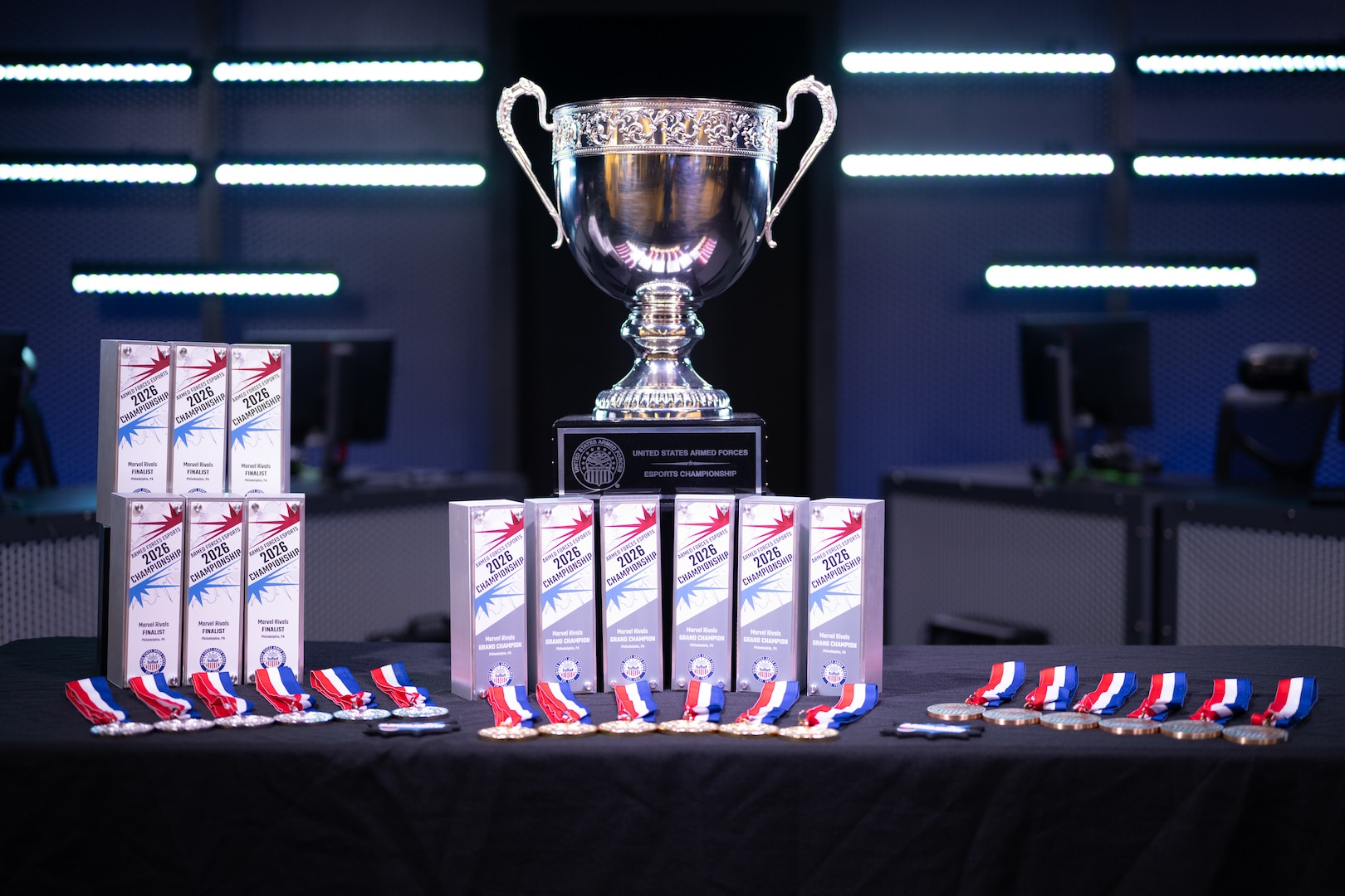 The championship trophy and awards are displayed on stage before the 2026 Armed Forces Esports Championship at Localhost in Philadelphia, Pennsylvania, April 25, 2026. Service members competed in organized esports competition playing Marvel Rivals for championship honors while representing their respective services. Armed Forces Sports brings together service members from the Army, Marine Corps, Navy, Coast Guard, and Air Force, and Space Force to compete at the national level. Armed Forces Sports promotes physical fitness, cognitive readiness, teamwork, and competitive opportunities for military members while supporting recruitment and retention efforts and strengthening partnerships through emerging sports platforms. (DoW photo by U.S. Marine Corps Sgt. Kayla Halloran)Service members competed in organized esports competition playing Marvel Rivals for championship honors while representing their respective services. Armed Forces Sports brings together service members from the Army, Marine Corps, Navy, Coast Guard, and Air Force, and Space Force to compete at the national level. Armed Forces Sports promotes physical fitness, cognitive readiness, teamwork, and competitive opportunities for military members while supporting recruitment and retention efforts and strengthening partnerships through emerging sports platforms. (DoW photo by U.S. Marine Corps Sgt. Kayla Halloran)