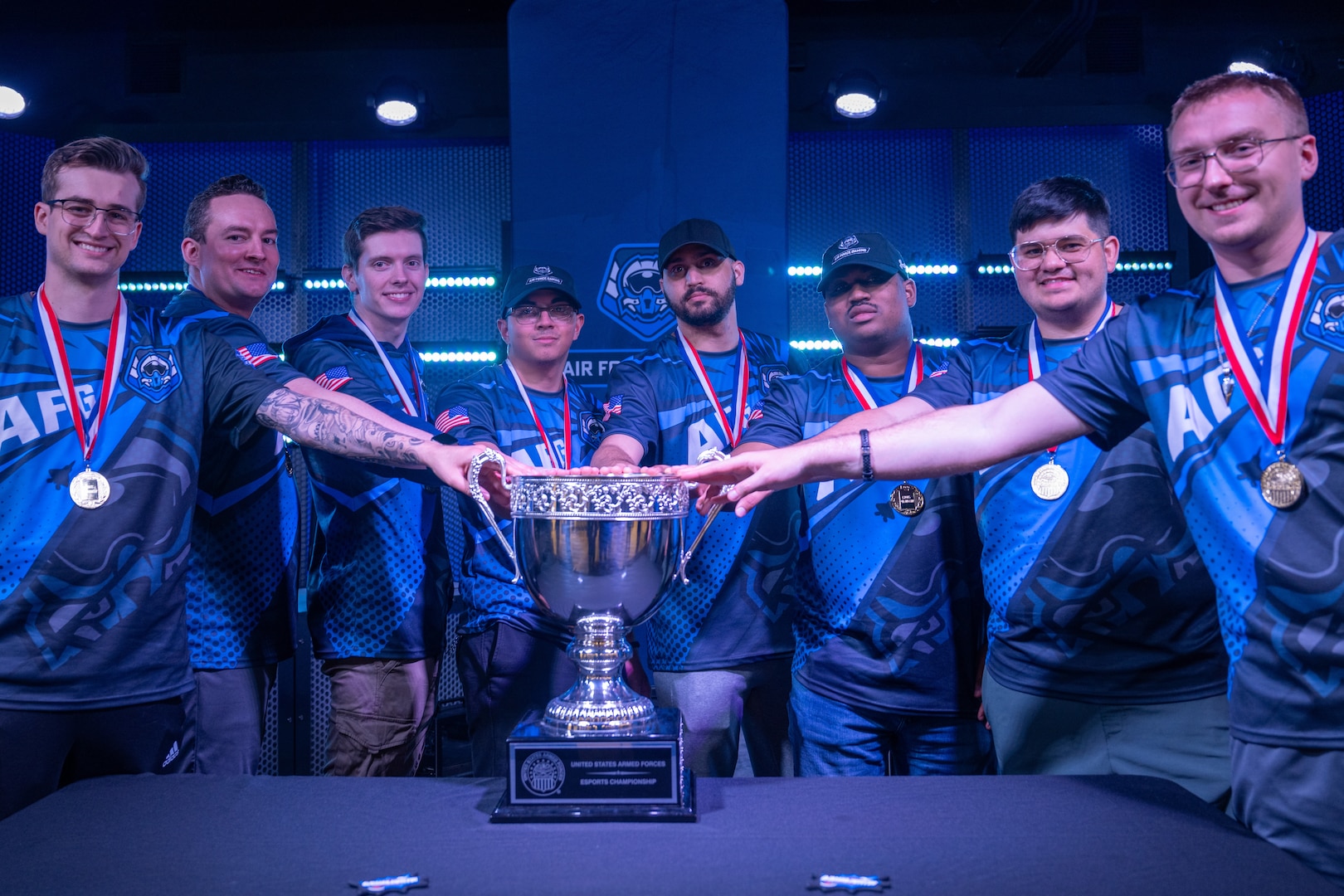 U.S. Service members pose beside a championship trophy after winning the 2026 Armed Forces Esports Championship at Localhost in Philadelphia Pennsylvania, April 25, 2026. Service members competed in organized esports competition playing Marvel Rivals for championship honors while representing their respective services. Armed Forces Sports brings together service members from the Army, Marine Corps, Navy, Coast Guard, Air Force, and Space Force to compete at the national level. Armed Forces Sports promotes physical fitness, cognitive readiness, teamwork, and competitive opportunities for military members while supporting recruitment and retention efforts and strengthening partnerships through emerging sports platforms. (DoW photo by U.S. Navy Mass Communication Specialist 2nd Class Christopher Suarez)