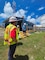 A man in a hard hat and safety vest looks at a person coming down stairs at a large fuel facility