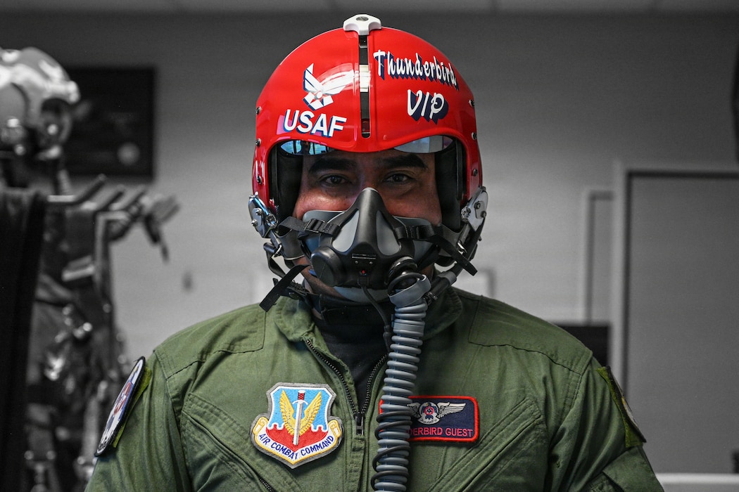 A man poses for a photo in a jet helmet.