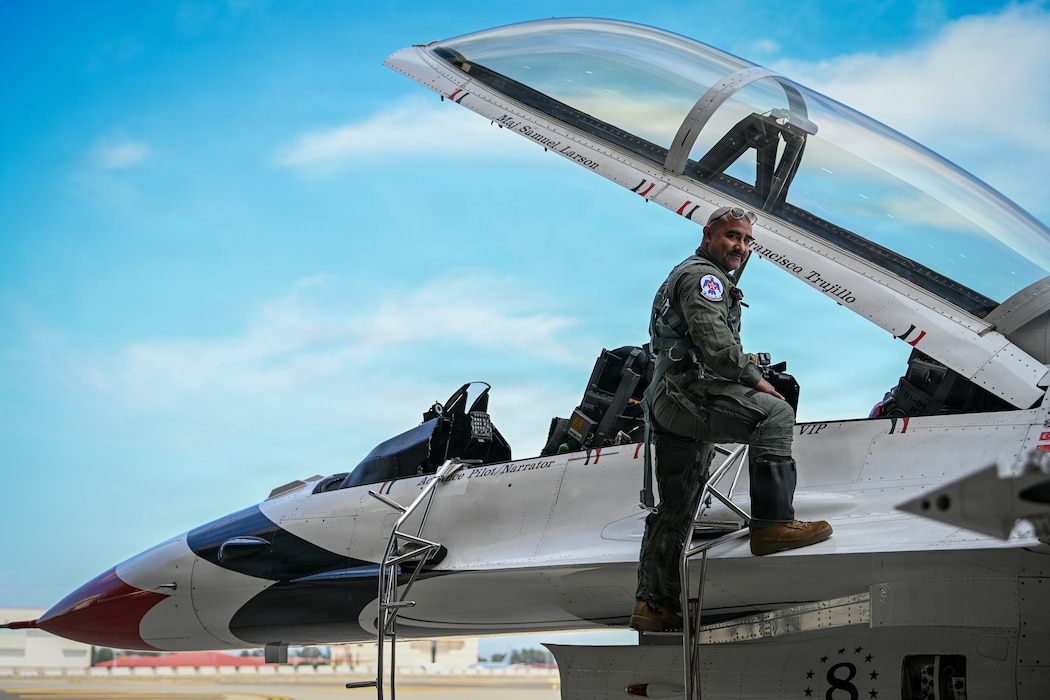 A man posing on the steps of a Fighter jet