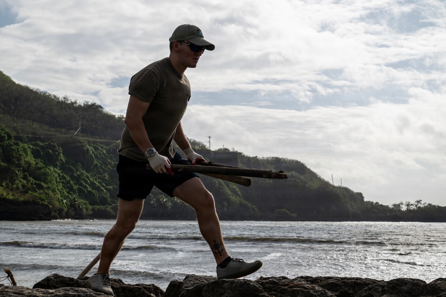 Electricians Mate (Nuclear) 1st Class Jakob Sanchez, assigned to the Performance Monitoring Team Guam at Commander, Submarine Squadron 15 (CSS-15), participates in a beach cleanup following Super Typhoon Sinlaku. CSS-15 and other military commands across Guam are providing vital support to villages and civil authorities, strengthening crisis response and recovery efforts in the wake of Super Typhoon Sinlaku. (U.S. Navy photo by Mass Communication Specialist 1st Class Bryan Mai)
