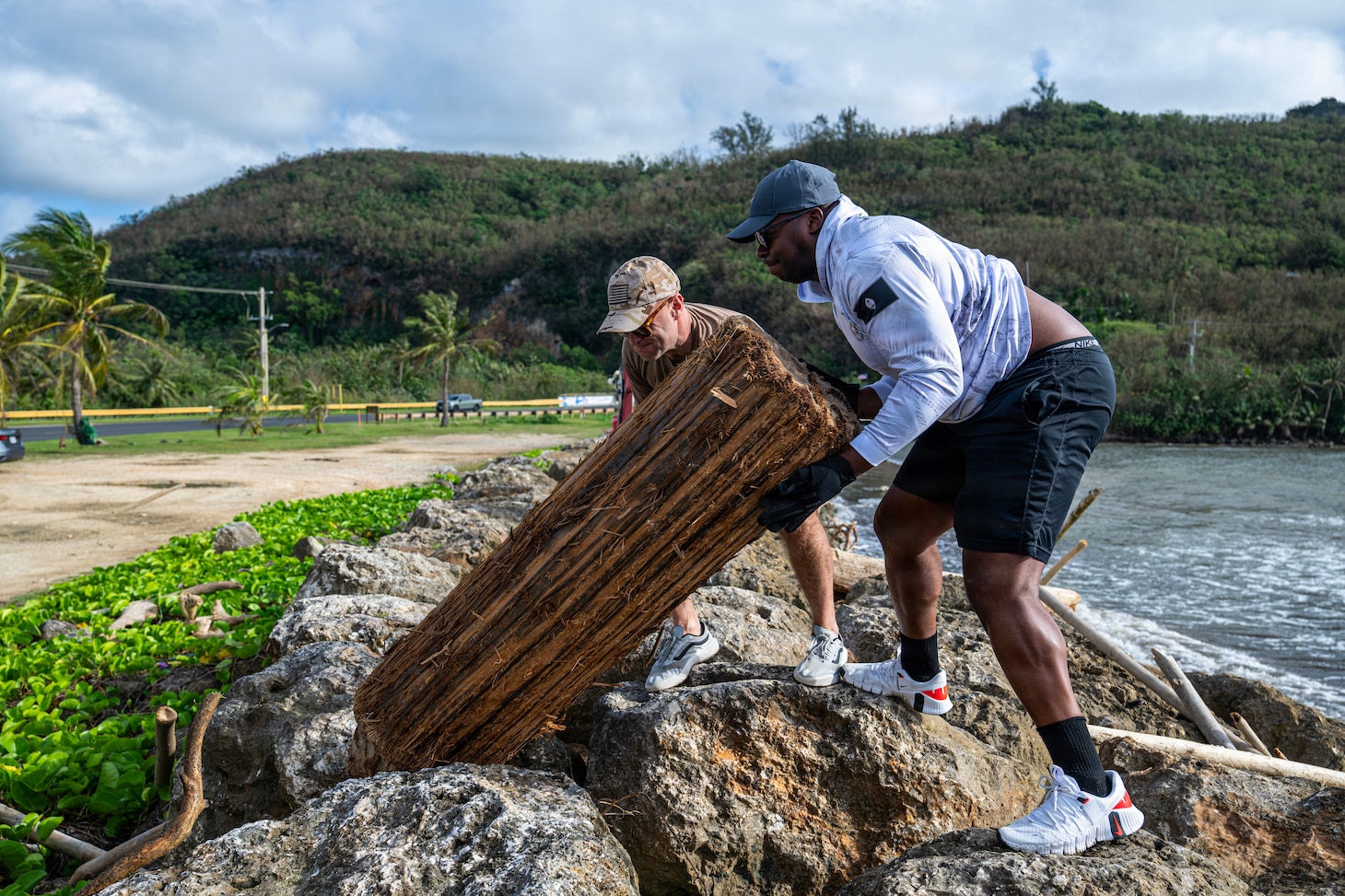Capt. Neil Steinhagen, commander of Commander, Submarine Squadron 15 (CSS-15), left, and Senior Chief Machinist Mate (Auxiliary) Class James Jones, assigned to CSS-15, participate in a beach cleanup following Super Typhoon Sinlaku. CSS-15 and other military commands across Guam are providing vital support to villages and civil authorities, strengthening crisis response and recovery efforts in the wake of Super Typhoon Sinlaku. (U.S. Navy photo by Mass Communication Specialist 1st Class Bryan Mai)