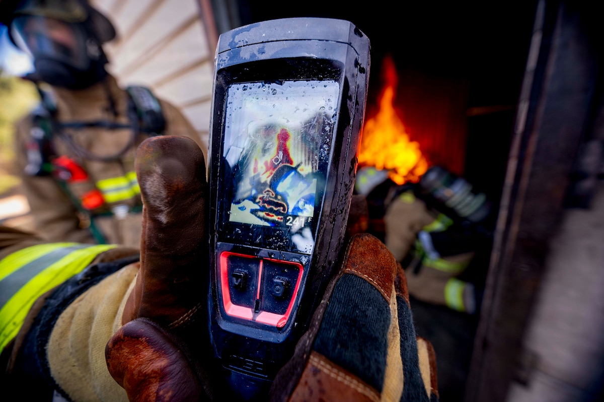 A U.S. Air Force 35th Civil Engineer Squadron firefighter uses a thermal imaging device during structural fire training  at Misawa Air Base, Japan, April 8, 2026. Advanced firefighting tools improve situational awareness and increase survivability. (U.S. Air Force photo by Senior Airman Gavin Hameed)