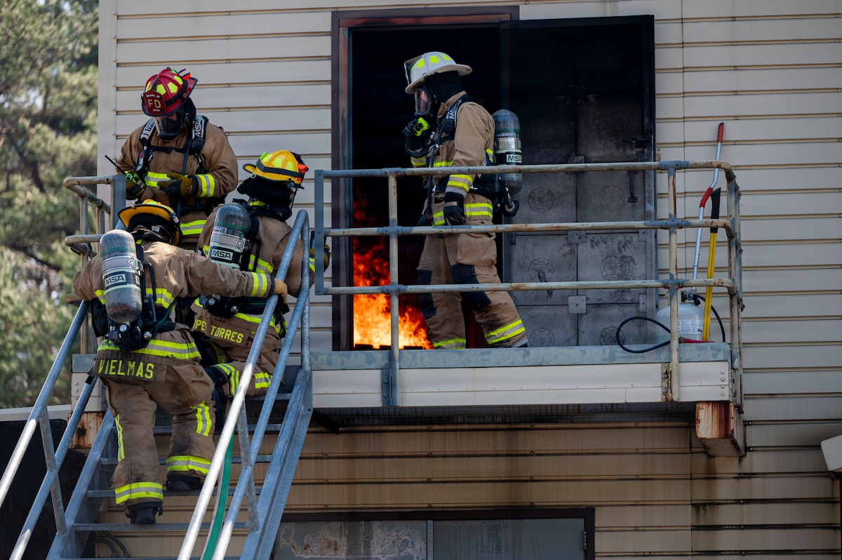 U.S. Air Force 35th Civil Engineer Squadron firefighters suppress a controlled structural fire during a bilateral training exchange at Misawa Air Base, Japan, April 8, 2026. The event allowed participants to observe coordinated entry and fire suppression procedures in a realistic environment.(U.S. Air Force photo by Senior Airman Gavin Hameed)