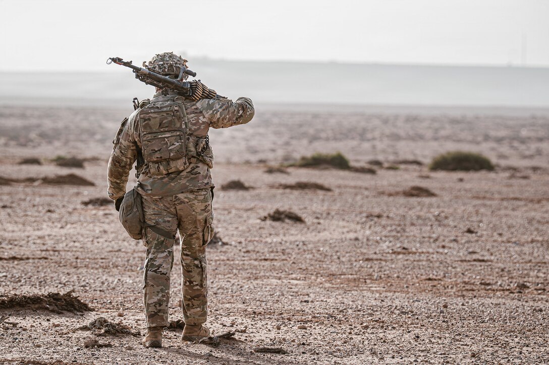 Carrying an M249 machine gun