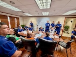 U.S. Coast Guard members of the Super Typhoon Sinlaku incident management team meet in Guam on April 27, 2026, to discuss updated objectives as they enter a new phase of the response focused on environmental recovery and marine safety. U.S. Coast Guard crews pressed north on April 19, 2026, ensuring the safety of Apra Harbor before moving toward communities still isolated by the effects of Super Typhoon Sinlaku, launching a coordinated surge to fully reopen ports across Guam and the Commonwealth of the Northern Mariana Islands and deliver resources. (U.S. Coast Guard photo by Chief Warrant Officer Sara Muir)