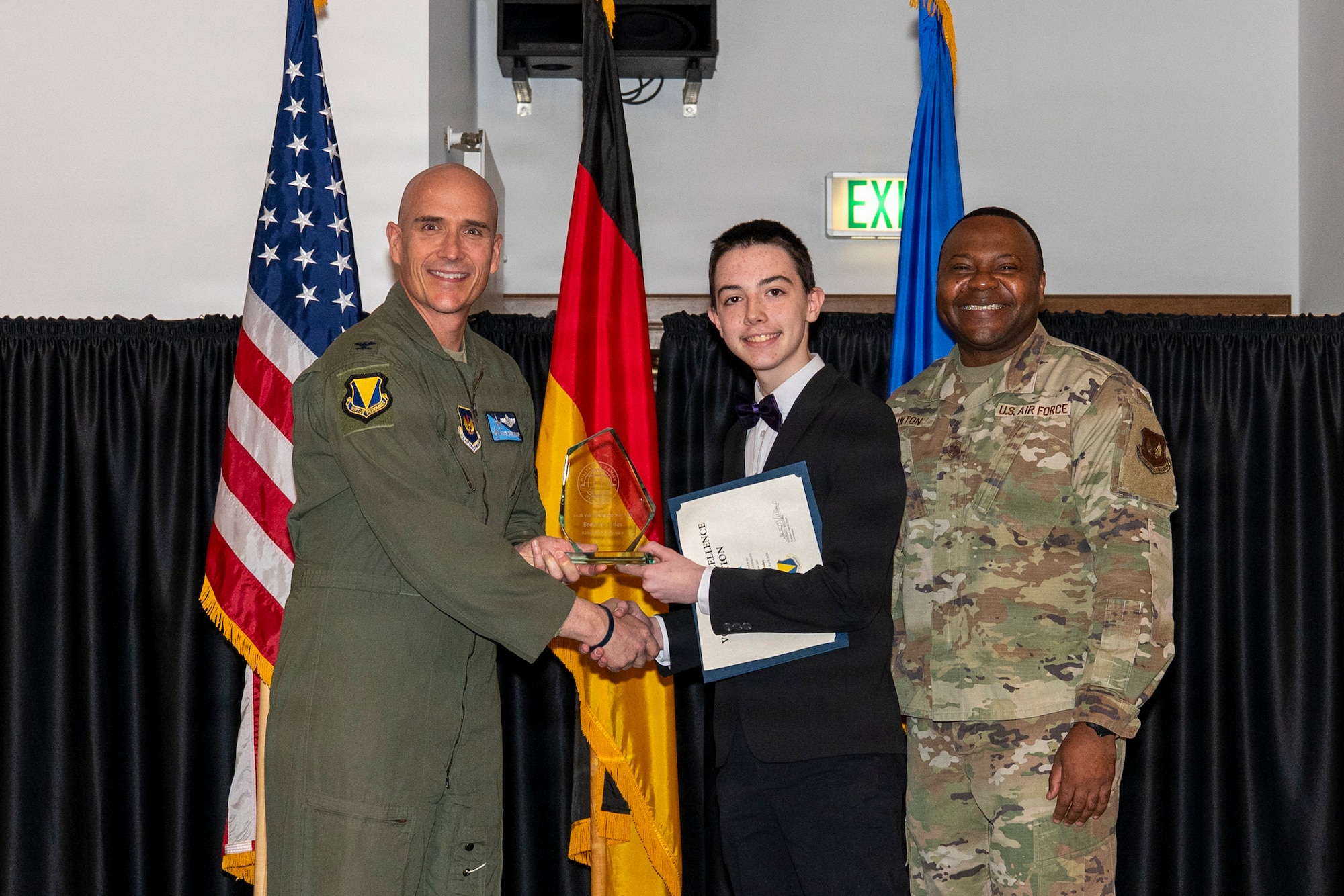 U.S. Air Force Col. Nathan Bump, 86th Airlift Wing deputy commander, presents a Volunteer Excellence Award to Brendyn Sides, youth category winner, at Ramstein Air Base, Germany, April 24, 2026.