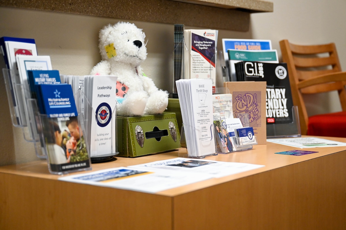 A table with pamphlets and a teddy bear.