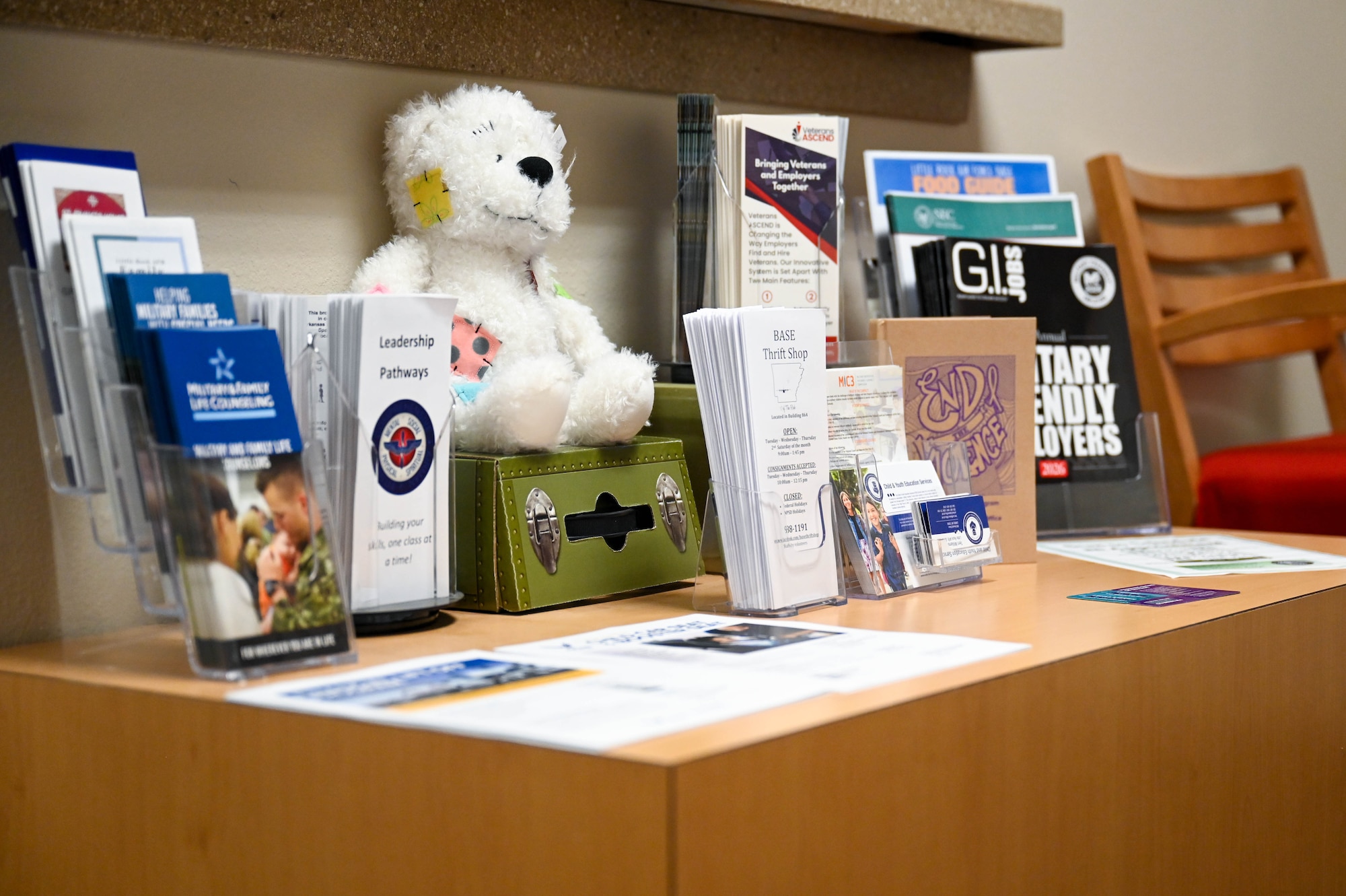 A table with pamphlets and a teddy bear.