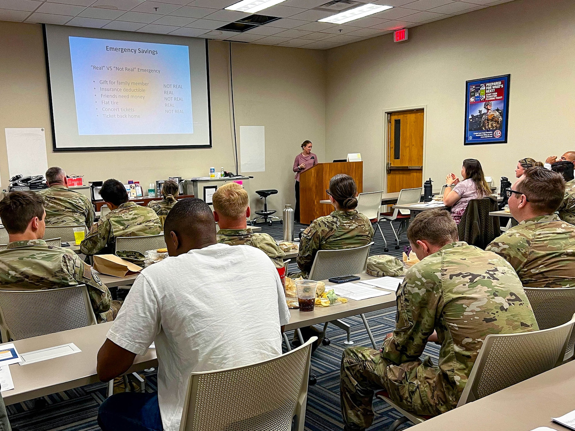 Airmen are sitting in a classroom listening to a instructor.