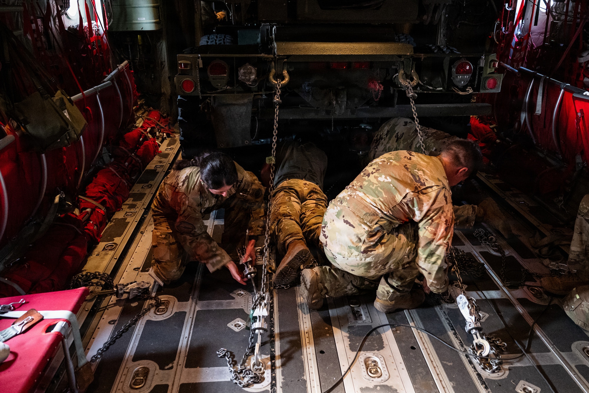 Airmen and Soldiers load a High Mobility Artillery Rocket System into a C-130 cargo plane