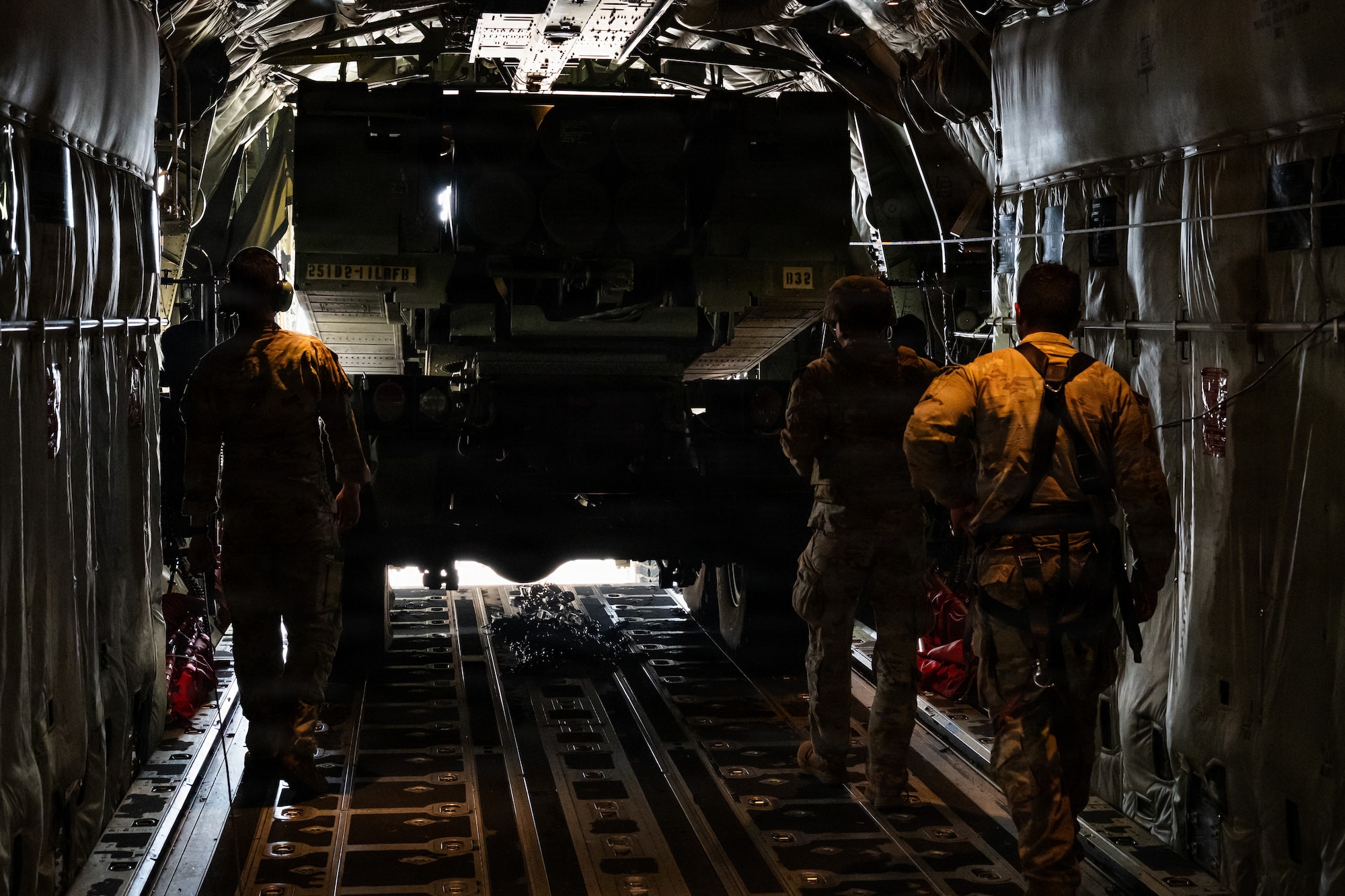 Airmen and Soldiers load a High Mobility Artillery Rocket System into a C-130 cargo plane