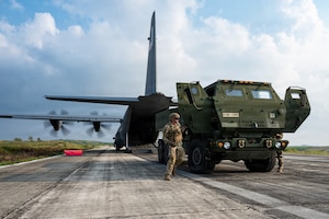 Airmen and Soldiers load a High Mobility Artillery Rocket System into a C-130 cargo plane