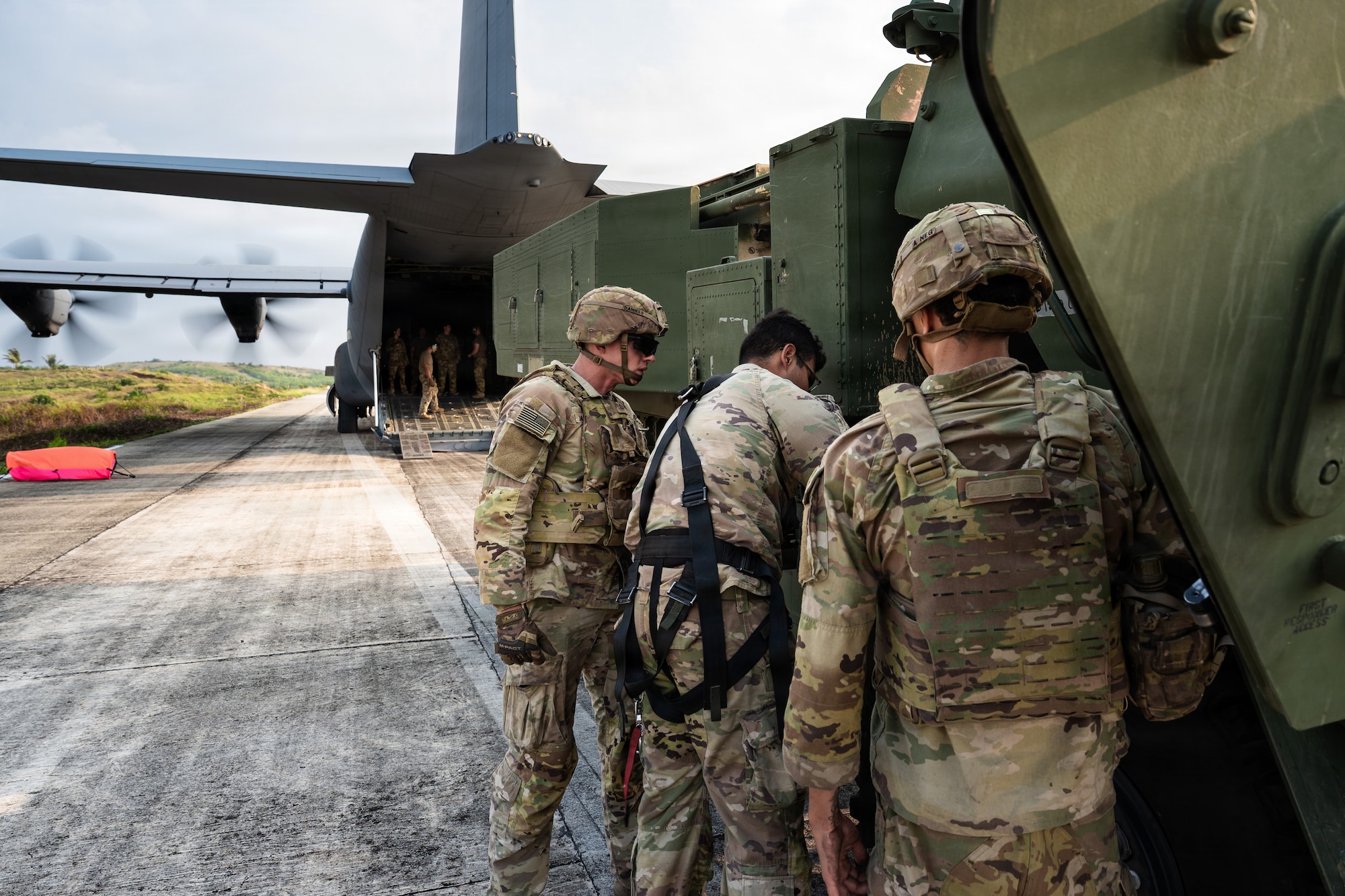 Airmen and Soldiers load a High Mobility Artillery Rocket System into a C-130 cargo plane