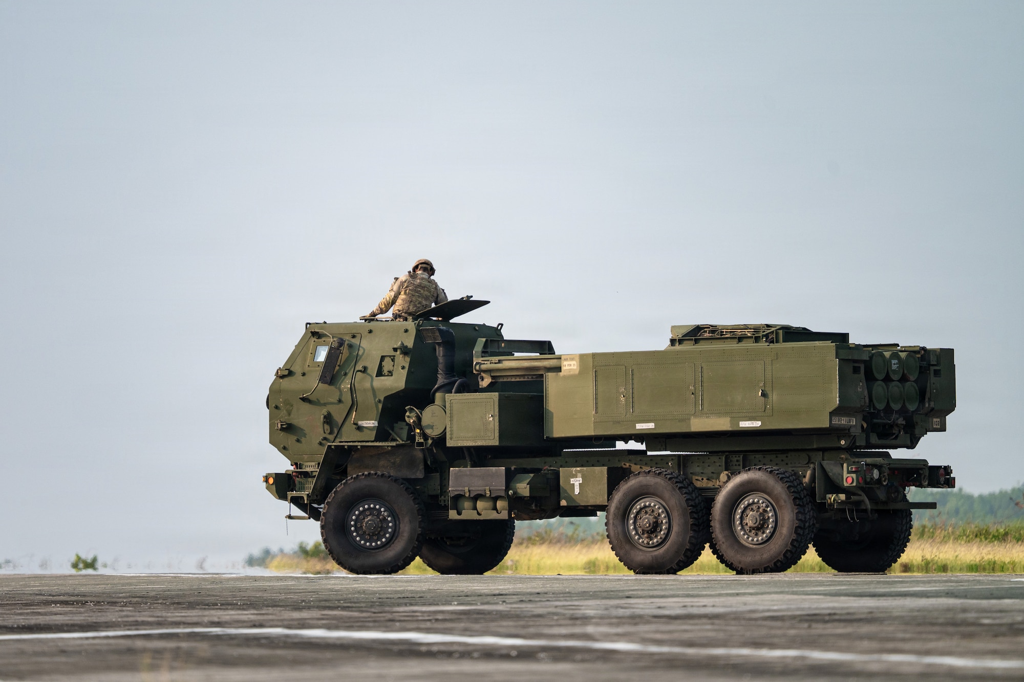 Airmen and Soldiers load a High Mobility Artillery Rocket System into a C-130 cargo plane