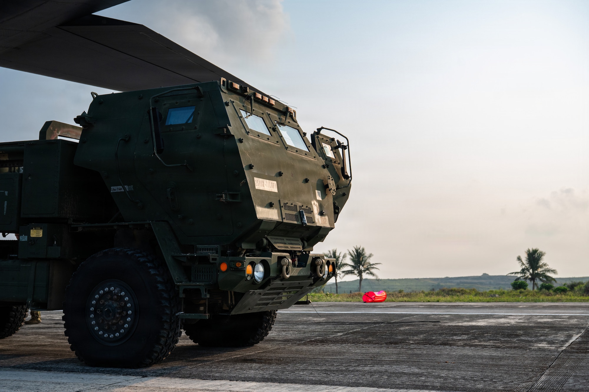 Airmen and Soldiers load a High Mobility Artillery Rocket System into a C-130 cargo plane