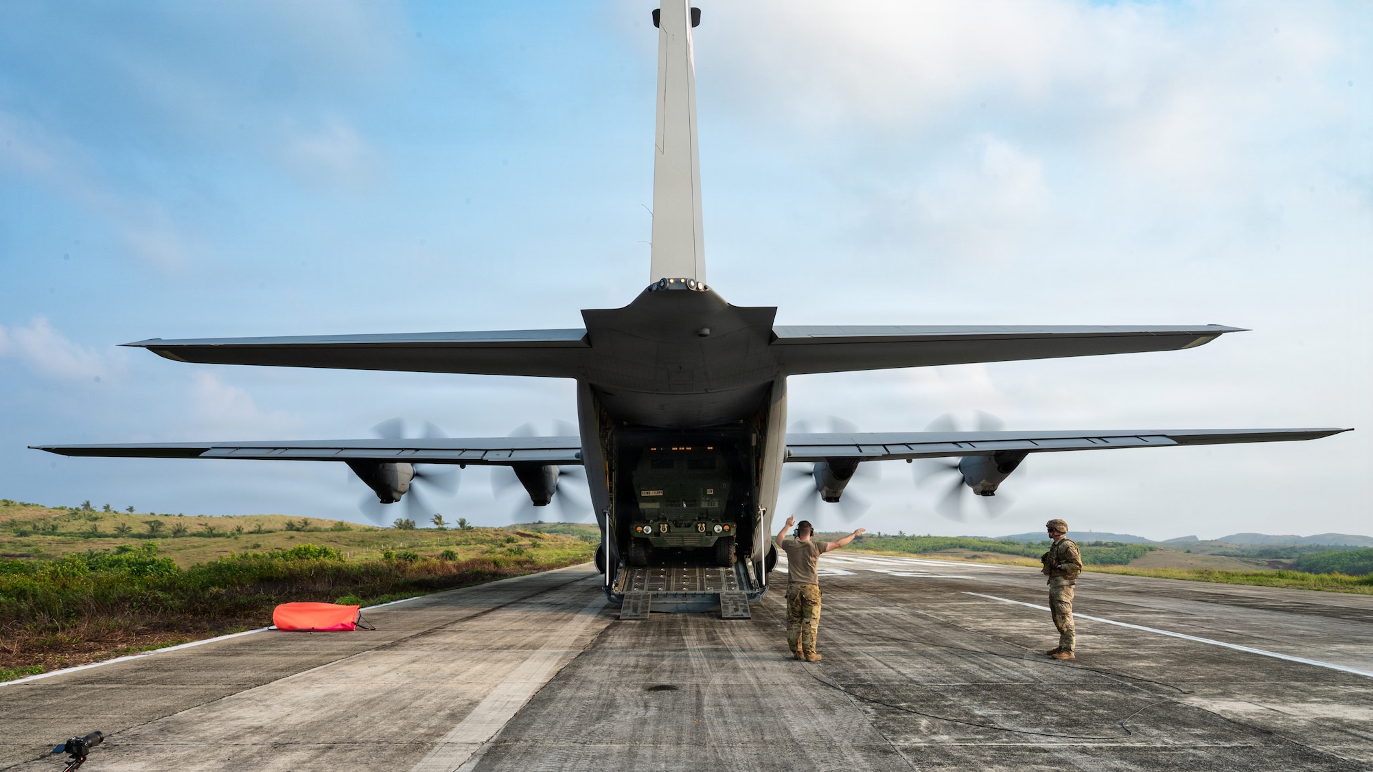 Airmen and Soldiers load a High Mobility Artillery Rocket System into a C-130 cargo plane