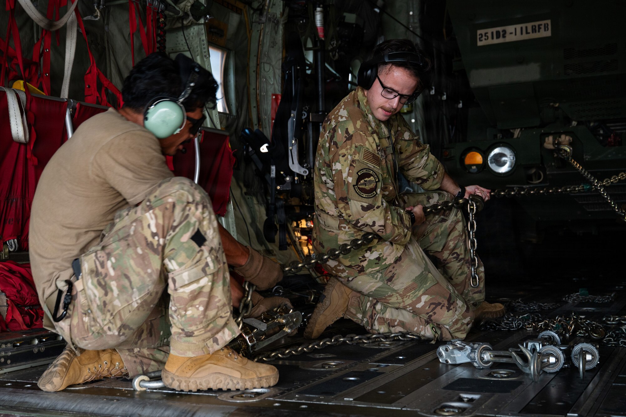 Airmen and Soldiers load a High Mobility Artillery Rocket System into a C-130 cargo plane
