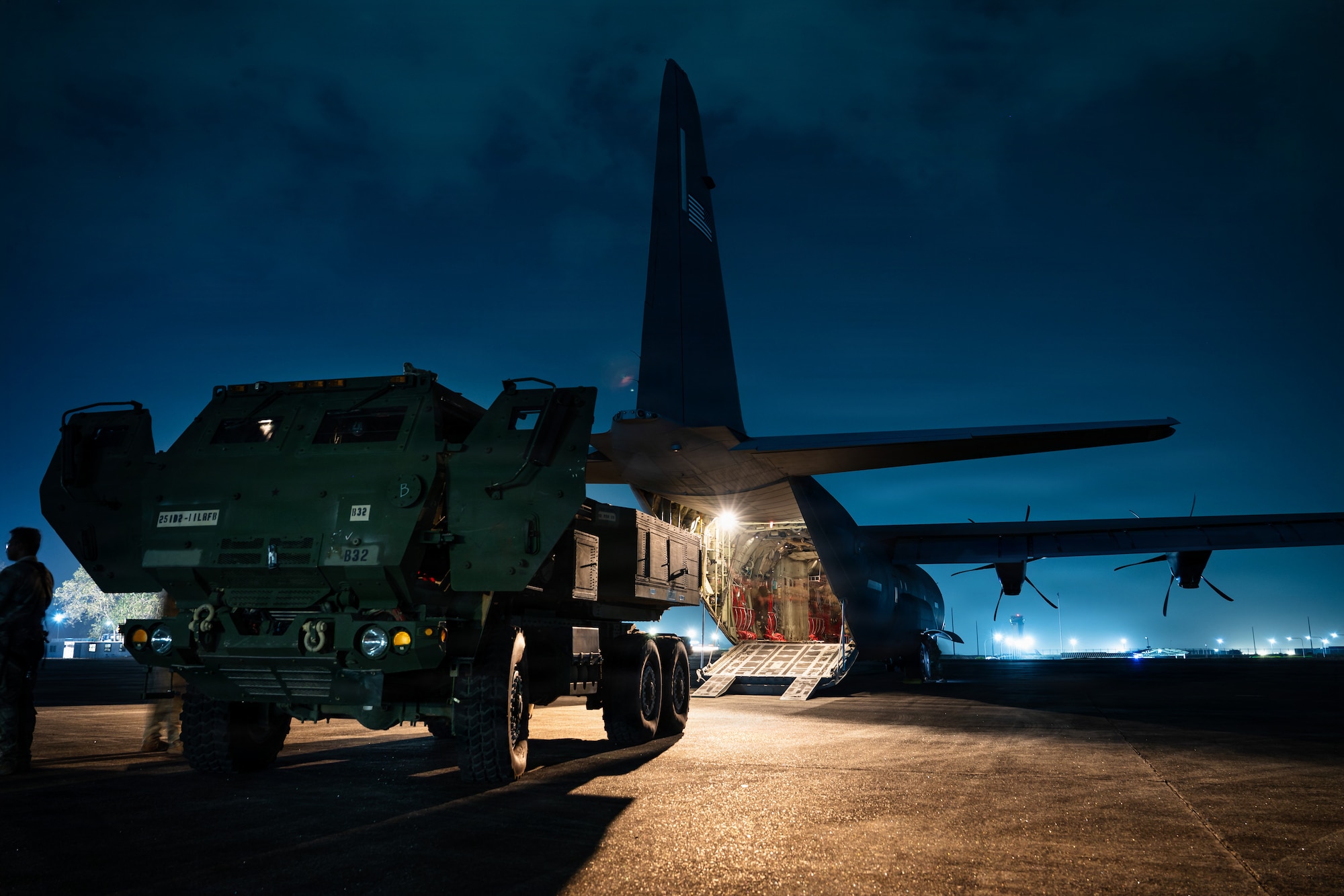 Airmen and Soldiers load a High Mobility Artillery Rocket System into a C-130 cargo plane