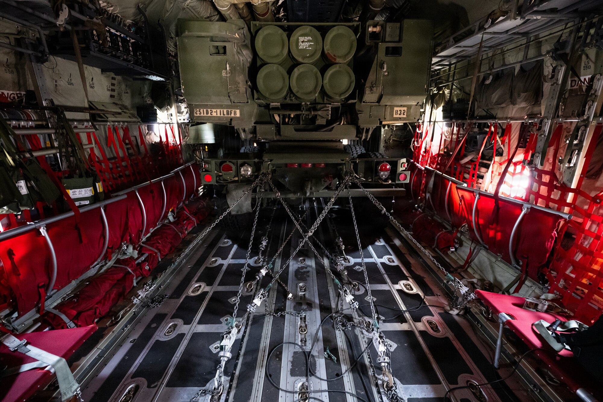 Airmen and Soldiers load a High Mobility Artillery Rocket System into a C-130 cargo plane