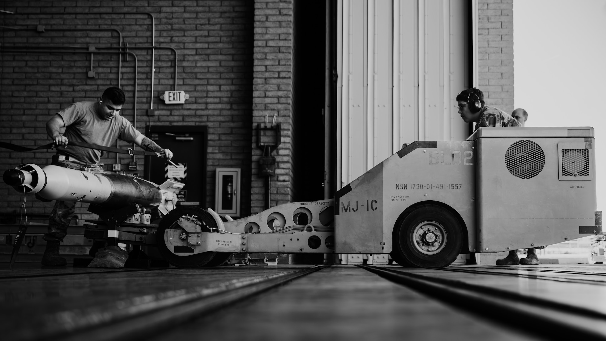 U.S. Air Force Staff Sgt. Devon Copeland and Senior Airman Jonathan Plancarte-Sedano, Aircraft Maintenance Unit weapons load crew members, secure a training missile and navigate a jammer