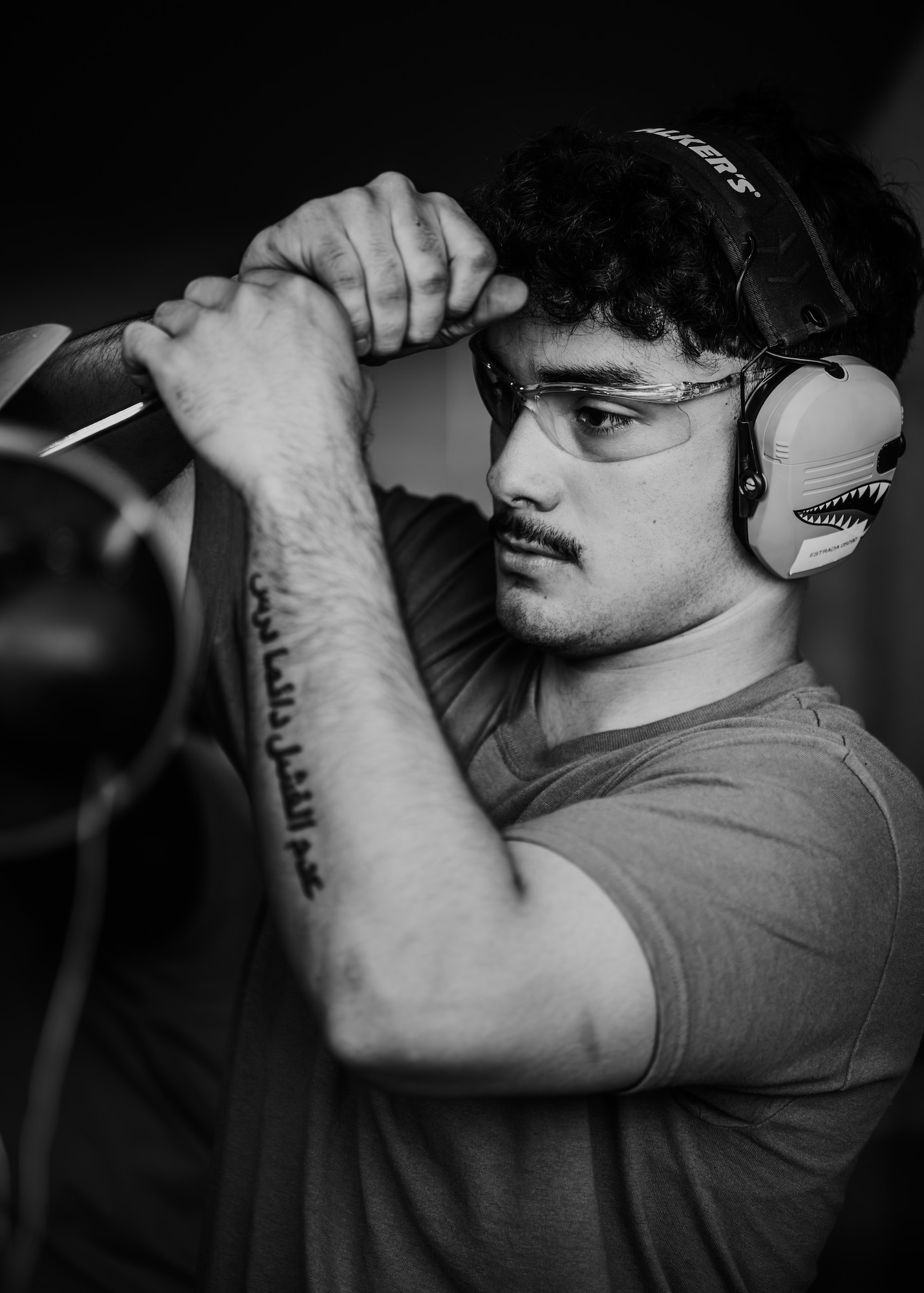 U.S. Air Force Airman 1st Class Carlos Estrada, 308th Aircraft Maintenance Unit weapons load crew member, secures a bomb rack panel by screwing in fasteners.