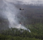 A CH-47 Chinook helicopter crew with B Company, 1st General Support Aviation Battalion, 169th Aviation Regiment, 78th Aviation Troop Command, Georgia Army National Guard, dumps water using a helicopter bucket during wildfire suppression efforts in Pineland, Georgia, April 25, 2026. Defense plays an integral role in declared emergencies by providing a versatile and ready force capable of responding to natural and manmade disasters across the United States. Photo by Sgt. Jordan McNeal.