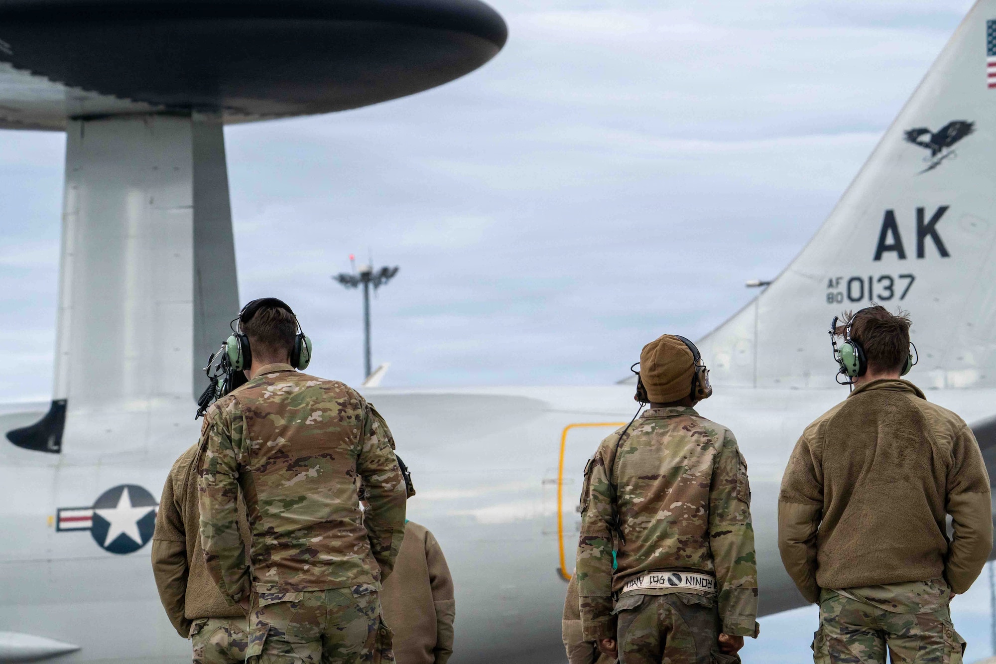 U.S. Air Force Airmen from the 718th Aircraft Maintenance Squadron and 961st Air Maintenance Unit watch an E-3 Sentry assigned to the 962nd Airborne Air Control Squadron taxi on the runway during Red Flag-Alaska 26-1 on Joint Base Elmendorf-Richardson, Alaska, April 23, 2026.