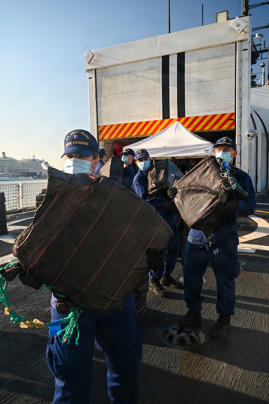 Crewmembers aboard USCGC Escanaba (907) pass along bale of cocaine during a drug offload of 7,050 pounds of narcotics at Port Everglades, Florida, April 27, 2026. The seized contraband was the result of one interdiction in the Caribbean Sea and one interdiction in the Eastern Pacific Ocean worth an estimated $53 million dollars. (U.S. Coast Guard photo by Petty Officer 2rd Class Eric Rodriguez)