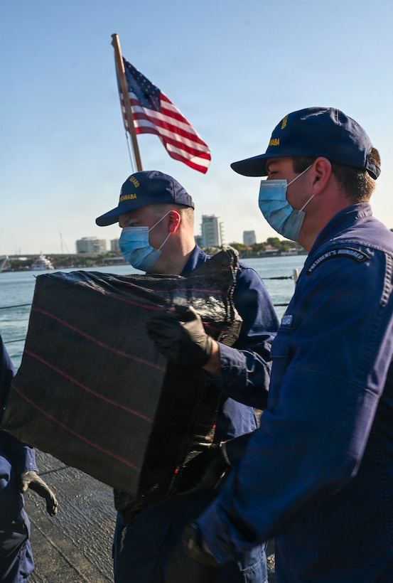 Crewmembers aboard USCGC Escanaba (907) pass along bale of cocaine during a drug offload of 7,050 pounds of narcotics at Port Everglades, Florida, April 27, 2026. The seized contraband was the result of one interdiction in the Caribbean Sea and one interdiction in the Eastern Pacific Ocean worth an estimated $53 million dollars. (U.S. Coast Guard photo by Petty Officer 2rd Class Eric Rodriguez)