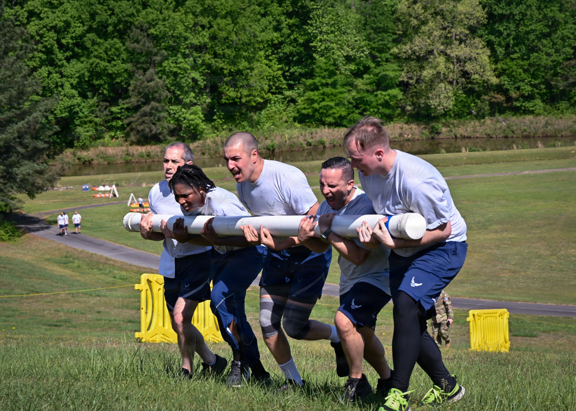 Airmen run uphill with PVC pipe