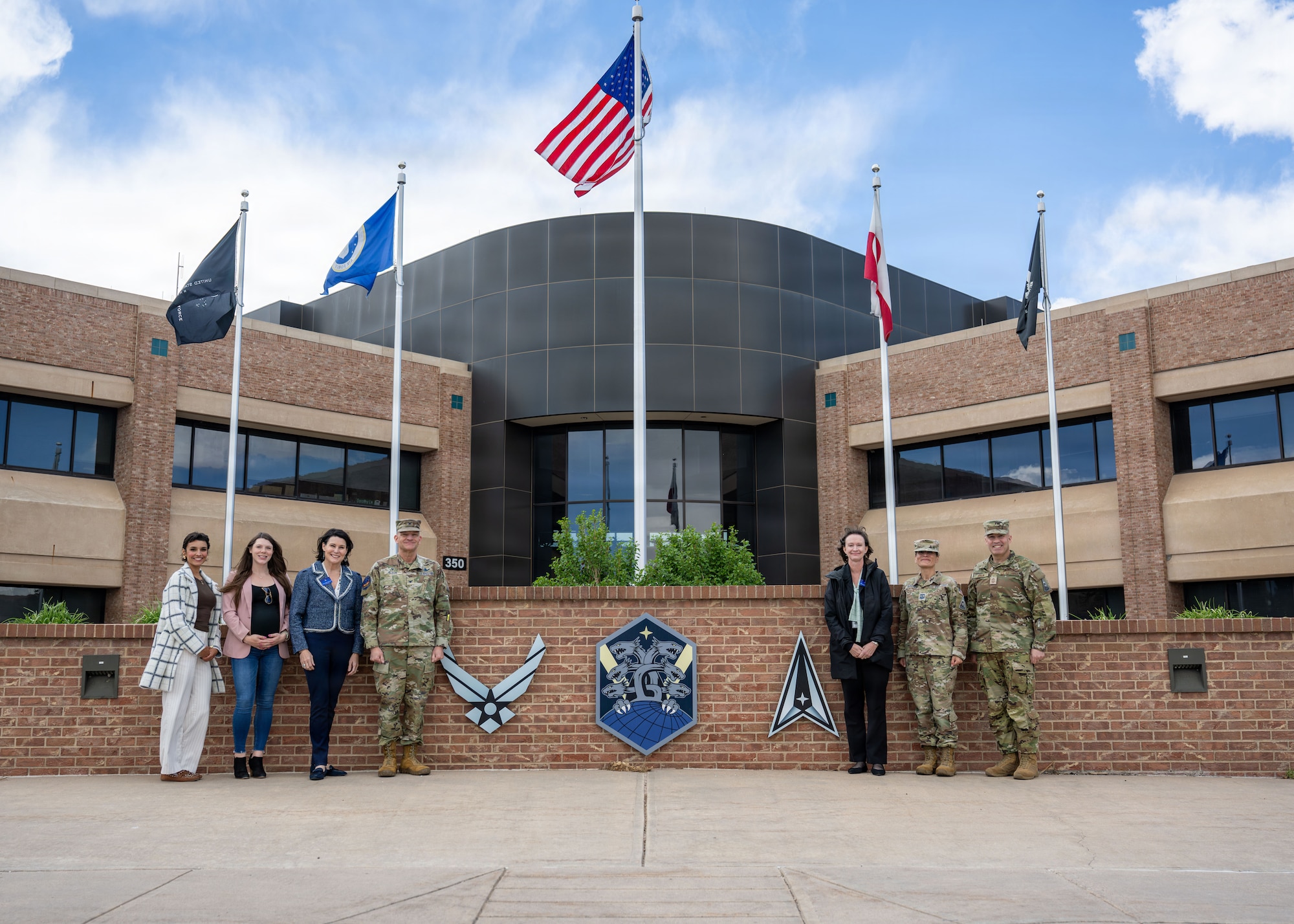 Members of a tour group pose for a photo in front of a building.