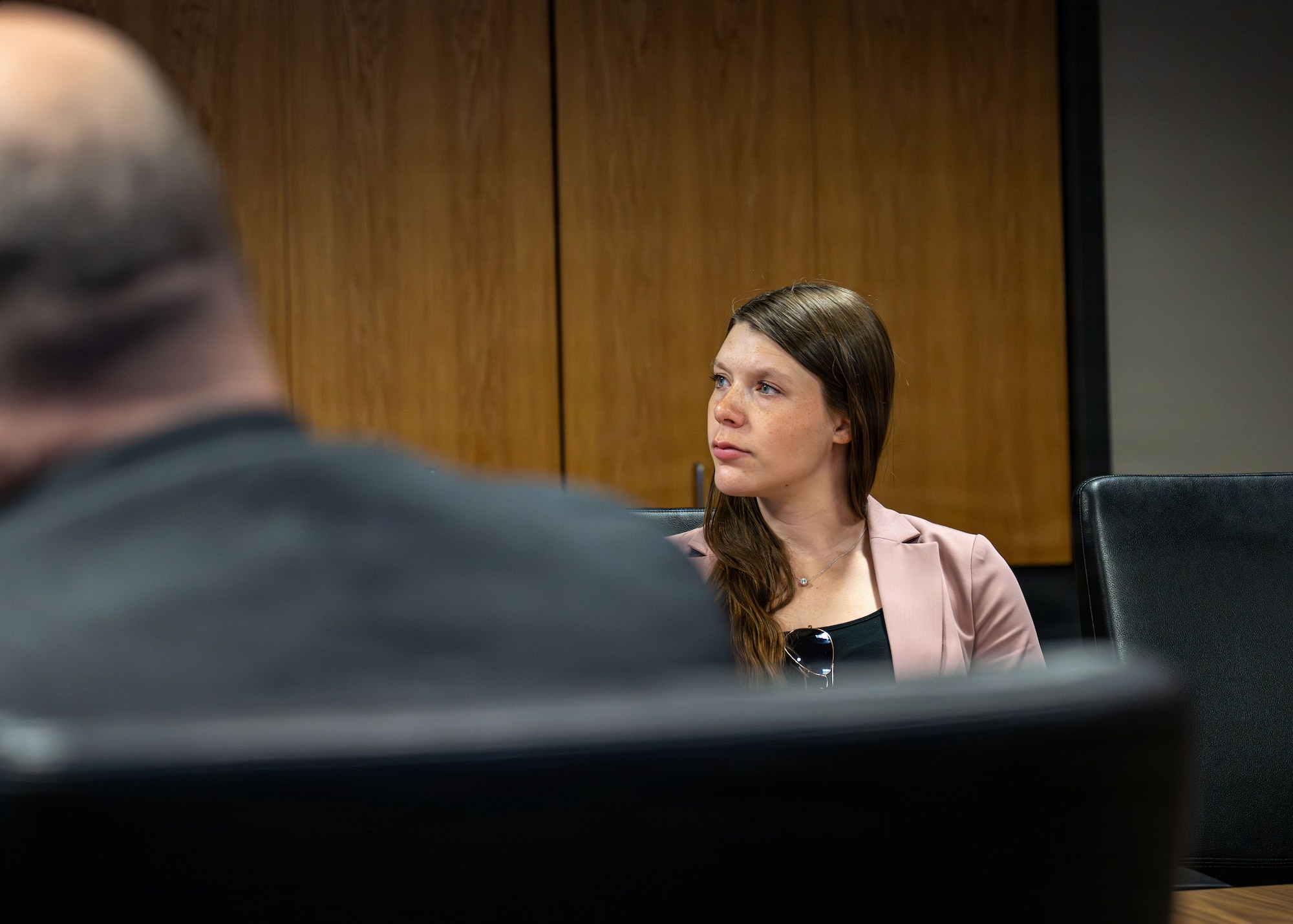 A woman watches a mission brief.