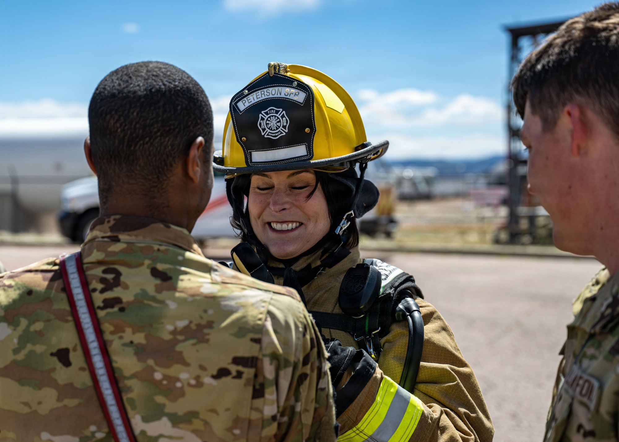 A woman puts on fire protection gear.