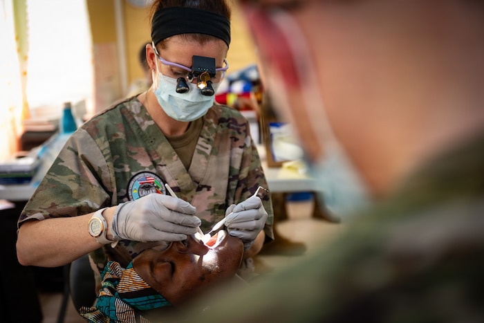 U.S. Air Force Reserve Maj. Kelsey Geiger, 434th Aerospace Medicine Squadron dentist, examines a patient's mouth during the Lesser Antilles Medical Assistance Team (LAMAT) 2026 mission at Medische Zending Primary Health Care Center Brownsweg, Suriname, April 15, 2026. Care focused on relieving pain and treating infection while supporting LAMAT 2026’s goal of improving access to care and strengthening regional partnerships. (U.S. Air Force photo by Staff Sgt. Madeline Herzog)
