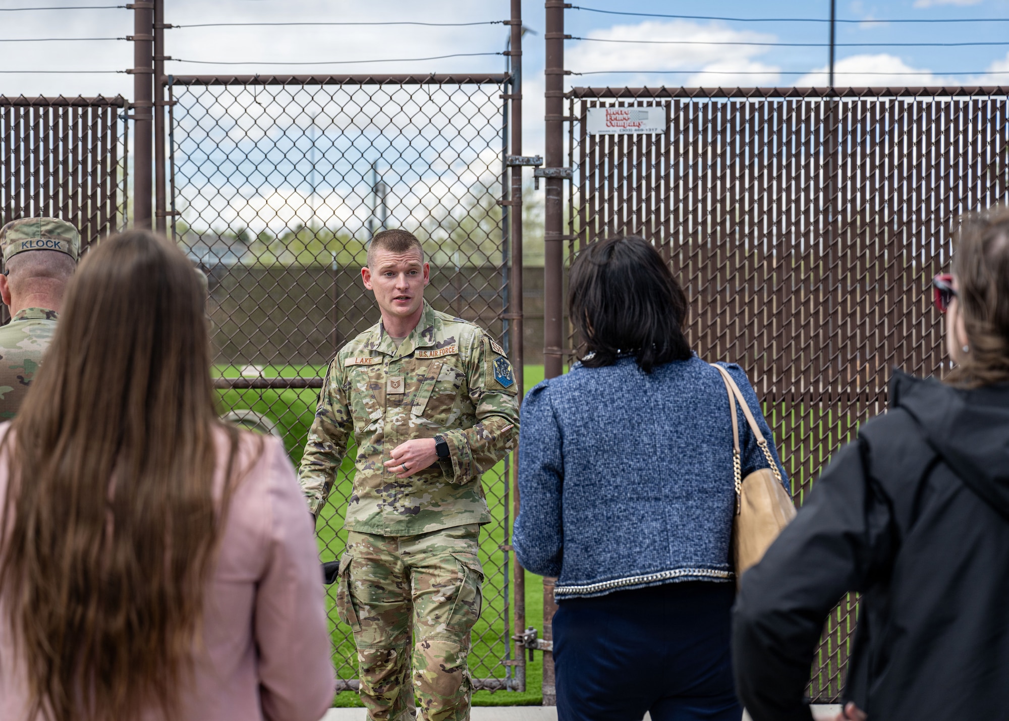 A military member takes a tour group through a military working dog training site.