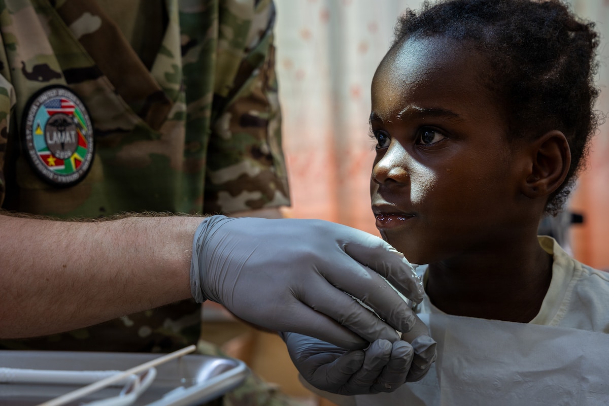 U.S. Air Force Tech. Sgt. Ryan Emrich, 434th Aerospace Medicine Squadron dental assistant, provides a rinsing cup for a child during a Lesser Antilles Medical Assistance Team (LAMAT) 2026 mission in Brownsweg, Suriname, April 15, 2026. U.S. Air Force medical personnel provided dental, optometry and primary care services in support of high patient volumes, improving access to care while enhancing readiness and strengthening regional partnerships. (U.S. Air Force photo by Staff Sgt. Joshua Hastings)