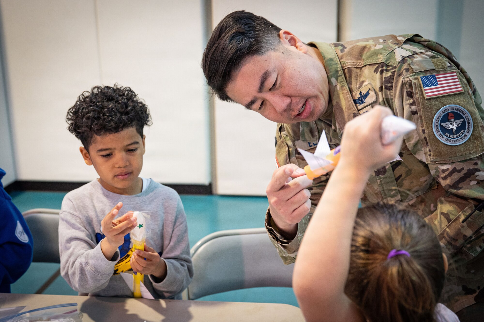 U.S. Space Force Lt. Col. Kaoru Elliott, United Space Forces-Japan deputy commander, engages with elementary school students during a Space Systems Command outreach event at Yokota Air Base, Japan, March 25, 2026. The goal of the outreach program is to foster early interest in science, technology, engineering, and math, promoting accessibility and curiosity in space-related systems. (U.S. Air Force photo by Senior Airman Jacob Wood)