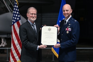 Steven D. Wert, left, retires Col. Scott Rothermel during a ceremony April 24, at the Museum of Aviation here. Rothermel, the senior materiel leader for Command and Control, Intelligence, Surveillance, and Reconnaissance retired after 30 years of service. Wert is a member of the Senior Executive Service and the Deputy Assistant Secretary for Acquisition Integration, Office of the Assistant Secretary of the Air Force for Acquisition, Technology and Logistics, the Pentagon, Arlington, Va. (Official Air Force Photo by Richard Blumenstein).