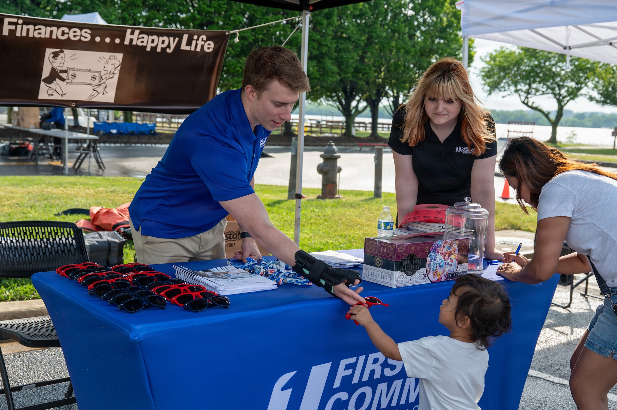 Gregory Curtin, left, a representative of First Command, hands sunglasses to a child at Spring Fest on Joint Base Anacostia-Bolling, Washington, D.C., April 24, 2026. The 11th Force Support Squadron hosted the event in celebration of the Month of the Military Child. (U.S. Air Force photo by Airman 1st Class Arlene Carrara)