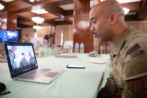 U.S. Airman speaks to service members on a laptop