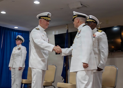 Cmdr. Matthew Faulkenberry, left, congratulates Cmdr. Christopher Gostel on assuming command of USS Cole (DDG 67) during the ship's change of command ceremony at Joint Expeditionary Base Little Creek-Fort Story, Virginia, April 23, 2026. Cmdr. Gostel relieved Cmdr. Faulkenberry as the 23rd commanding officer of USS Cole. (U.S. Navy photo by Mass Communication Specialist 3rd Class Wilschnaida Milfort)