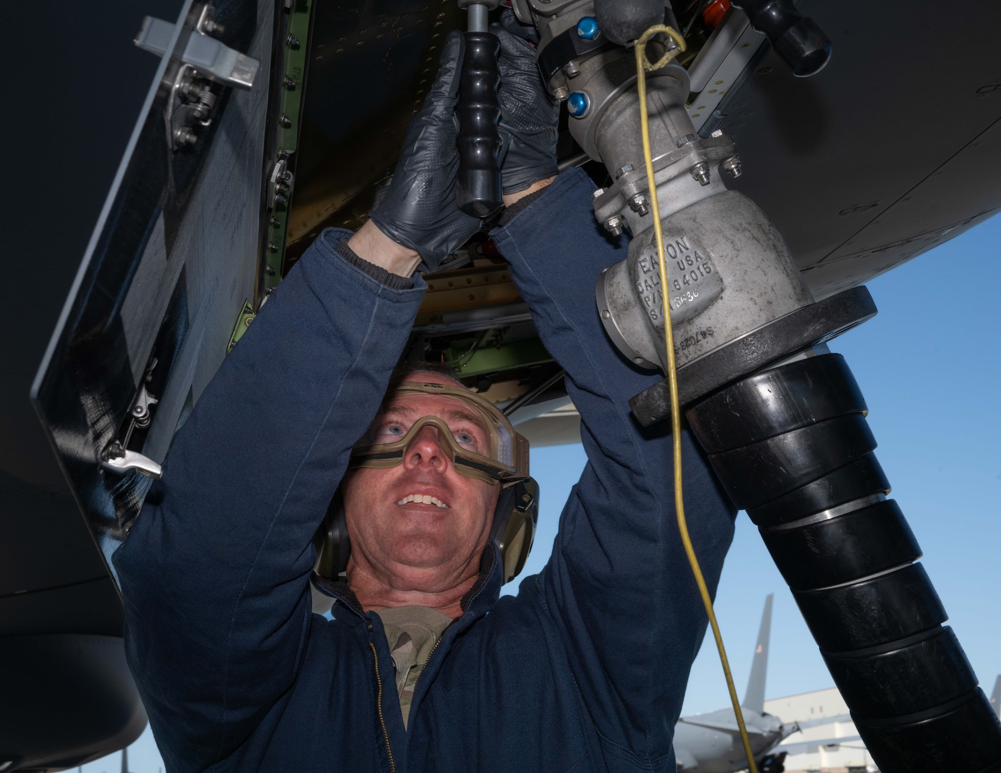 a U.S. Airman attaches a fuel hose to a KC-47 Pegasus