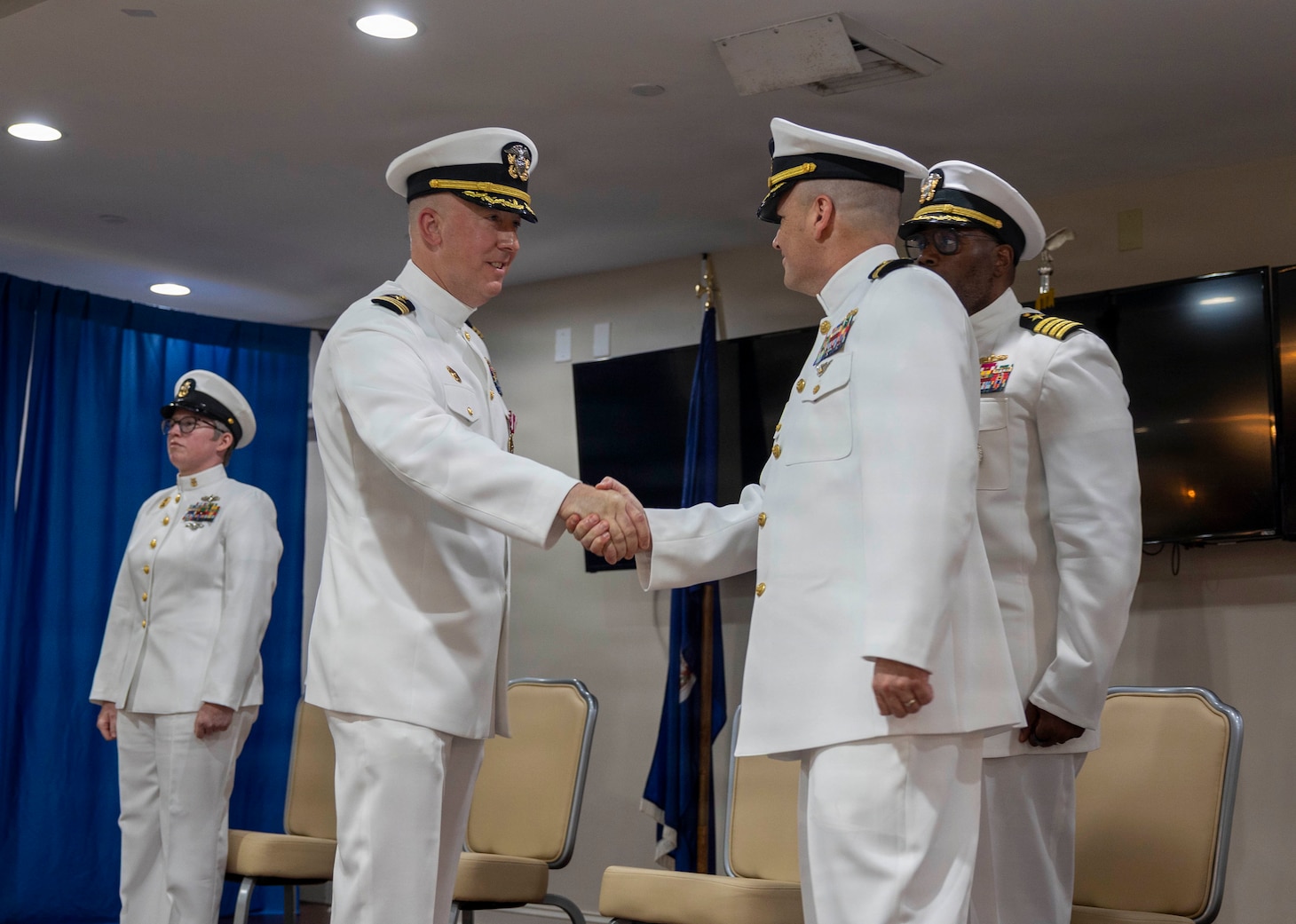 Cmdr. Matthew Faulkenberry, left, congratulates Cmdr. Christopher Gostel on assuming command of USS Cole (DDG 67) during the ship's change of command ceremony at Joint Expeditionary Base Little Creek-Fort Story, Virginia, April 23, 2026. Cmdr. Gostel relieved Cmdr. Faulkenberry as the 23rd commanding officer of USS Cole. (U.S. Navy photo by Mass Communication Specialist 3rd Class Wilschnaida Milfort)