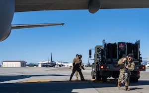 Three U.S. Airmen begin the process to fuel a KC-47 Pegasus from a fuel truck on the flight line at Travis Air Force Base.