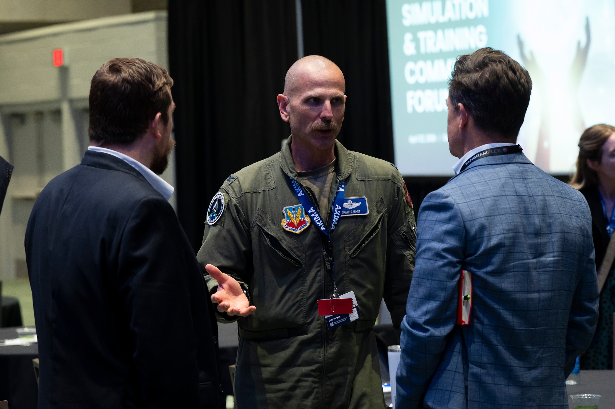 Three men standing, talking.