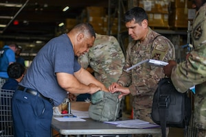 Members of Joint Base Andrews inspect gas mask equipment.